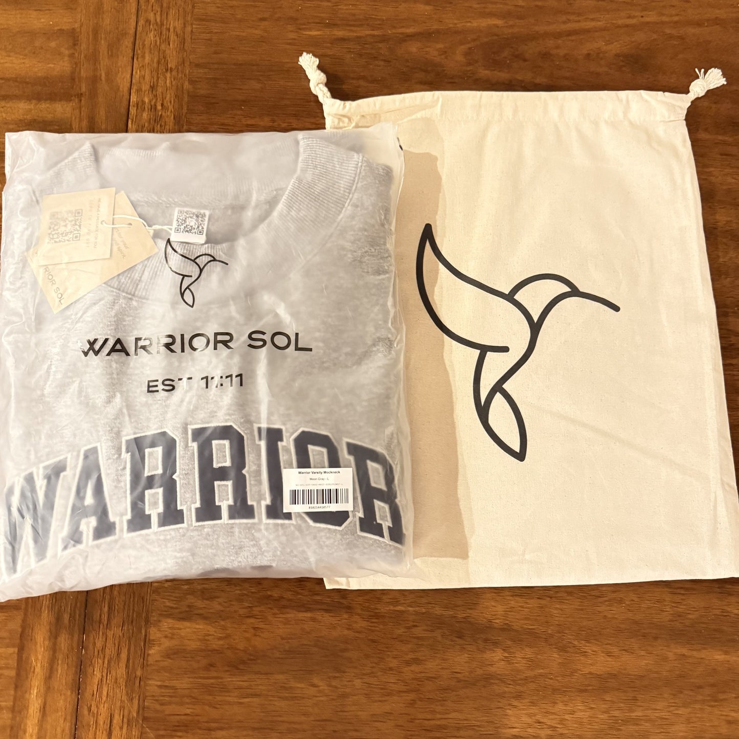Hummingbird bag next to a folded varsity mockneck for scale