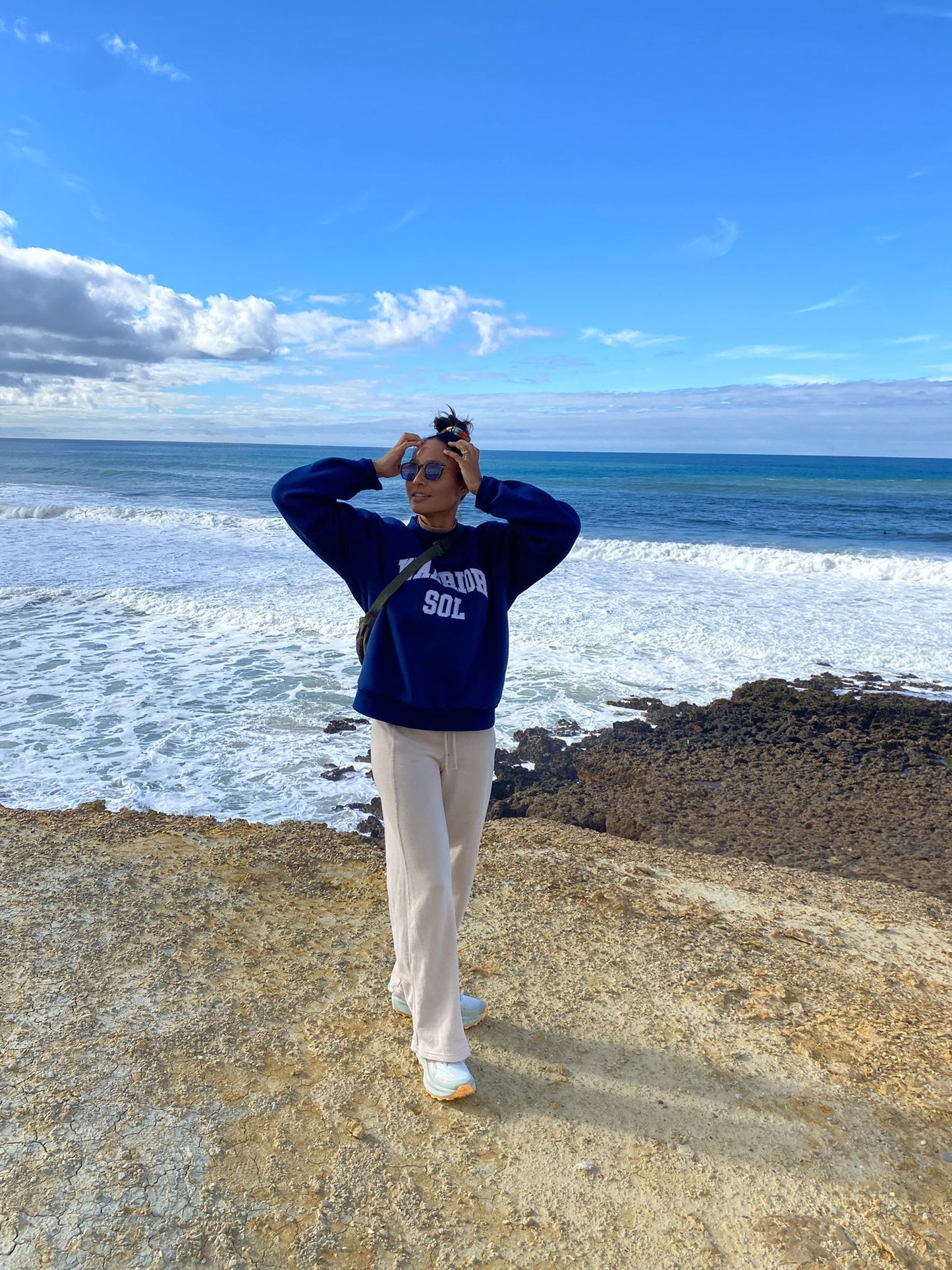 Woman at beach wearing Warrior Sol Varsity Mockneck in Midnight Blue