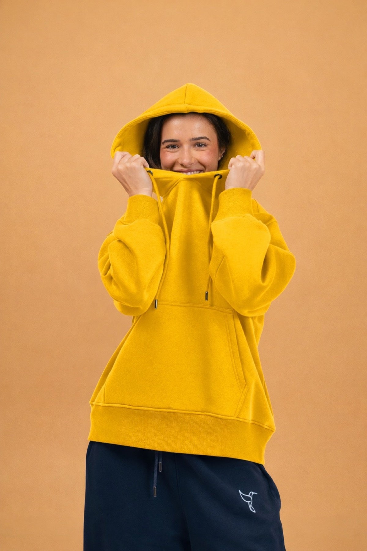 Comfy Pullover Hoodie in Sunshine Yellow — model wearing bright yellow hoodie with Warrior Sol hummingbird logo | Warrior Sol cancer support apparel
