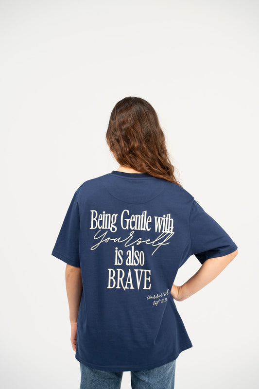 Woman wearing Warrior Sol Being Gentle T-Shirt in Midnight Blue, back view