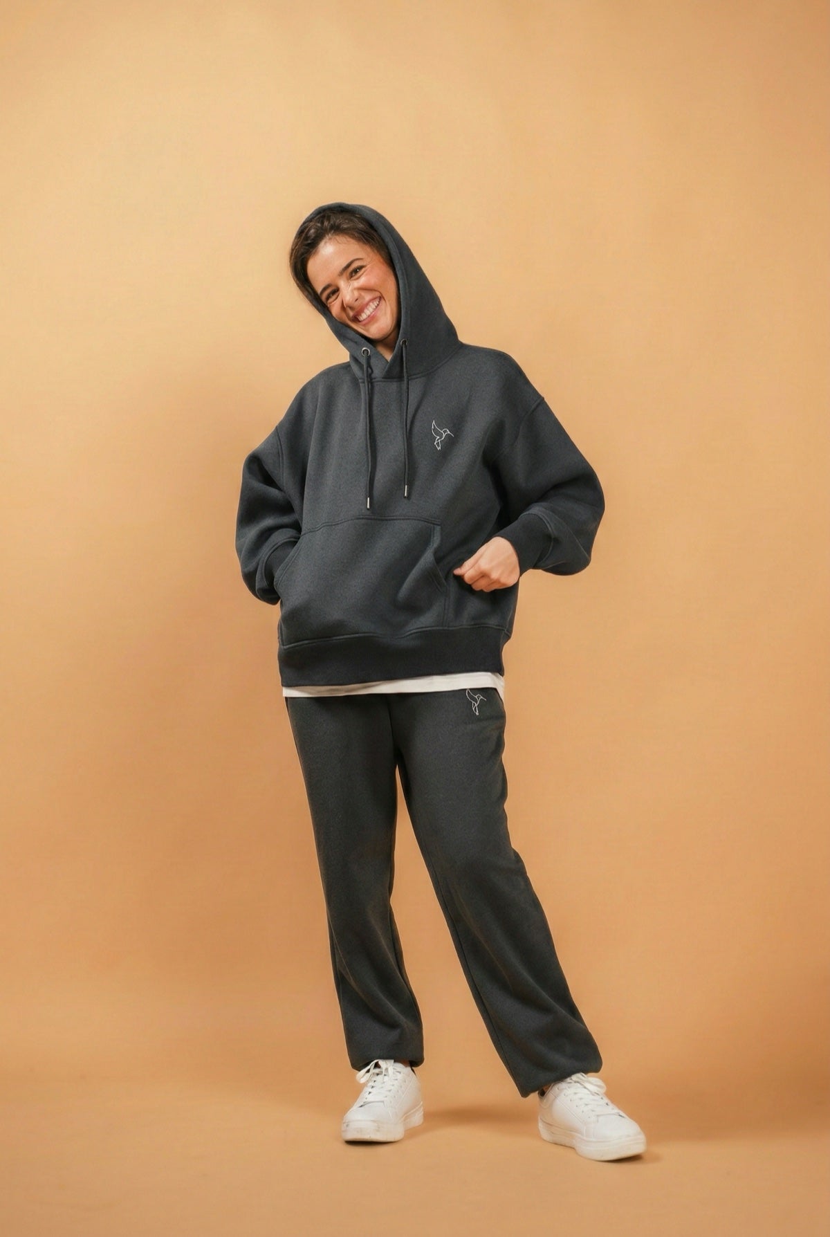 Warrior Sol Comfy Pullover Hoodie in Slate Gray — campaign photo on gold background, model wearing oversized slate gray hoodie with matching sweatpants
