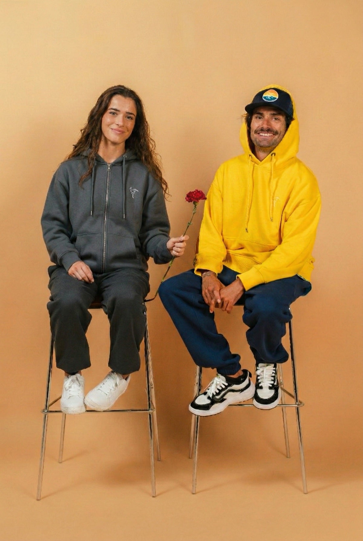 Warrior Sol ShieldUp Zip-Up Hoodie in Slate Gray both models on stools with rose gold campaign background